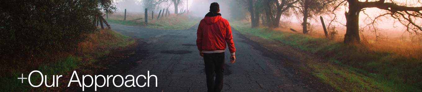 A man walking toward a fork in the road. Austin+Koffron's approach is to help you determine your path to your future.